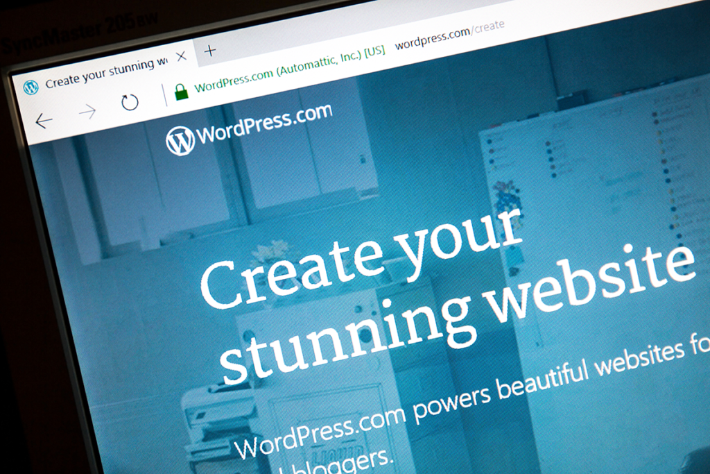 A digital screen is displaying the WordPress.org website, which says "Create your stunning website"